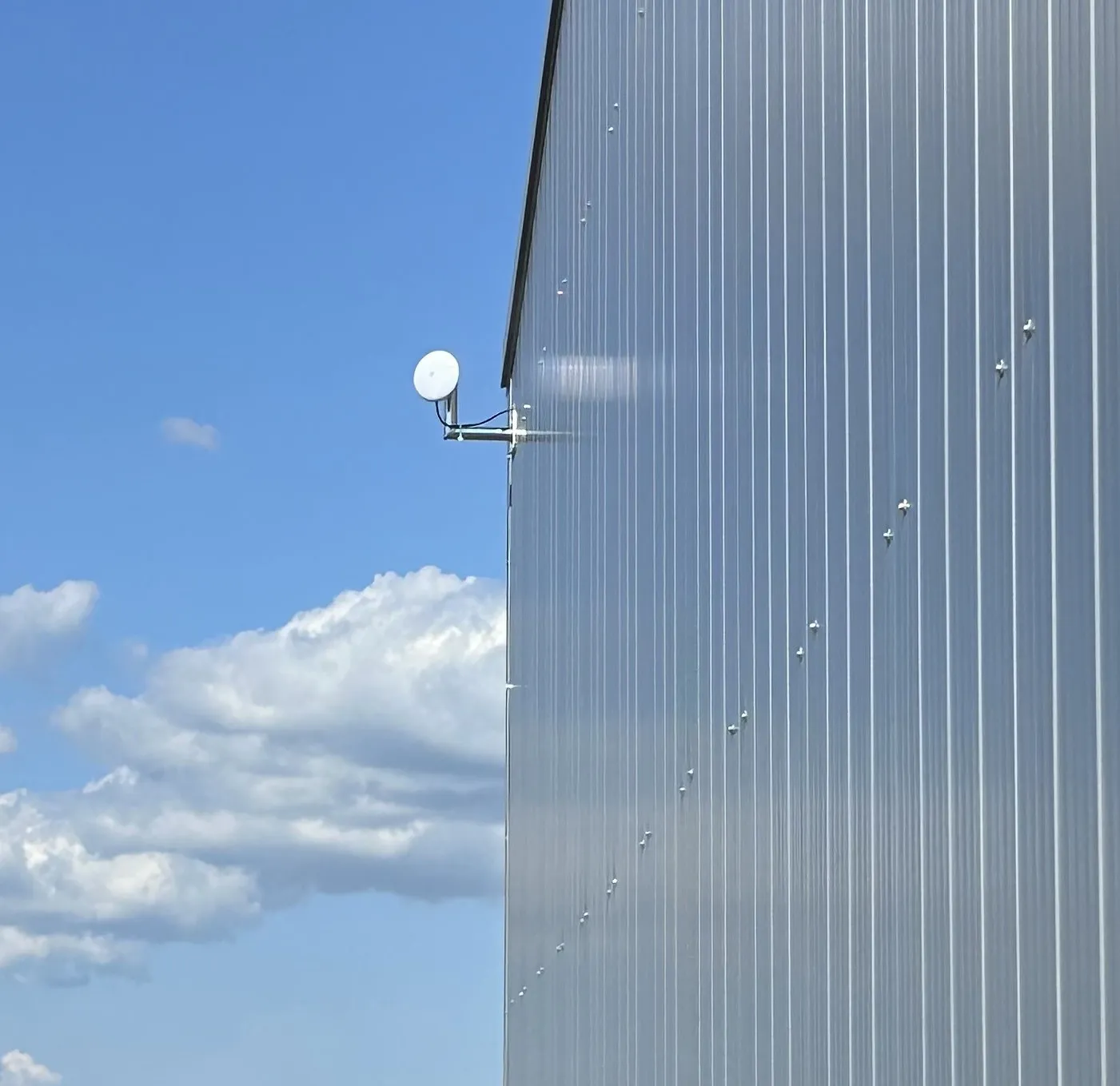 Ubiquiti-Richtfunkantenne an einer Fassade für die Verbindung einer entfernten Überwachungskamera