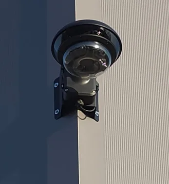 10 Kamera Überwachungssystem an einer Firmenfassade – zwei Bullet-Kameras in Doppelmontage an Stahltrapezblech zur Eckabdeckung mit überlappenden Erfassungsbereichen