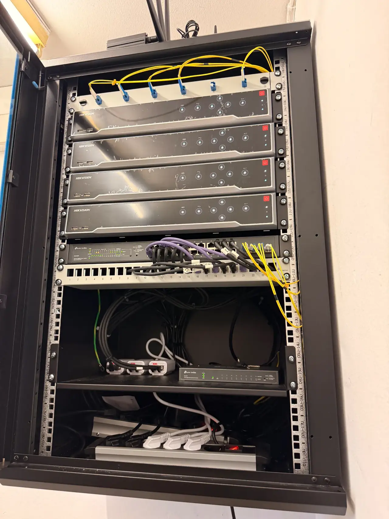 Hikvision NVR-Rack mit Recordern, PoE-Switch und Patchpanel – professionelle Videoüberwachung für Unternehmen in Deutschland