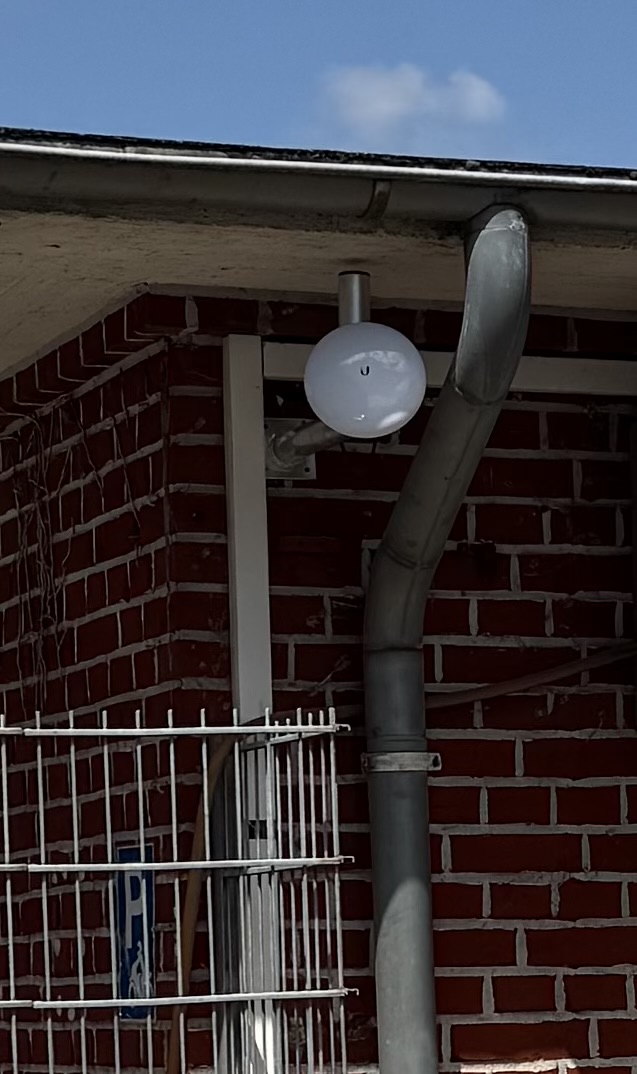 Ubiquiti Richtfunk-Antenne an Hausfassade montiert – WLAN-Brücke für Punkt-zu-Punkt Verbindung zwischen zwei Gebäuden
