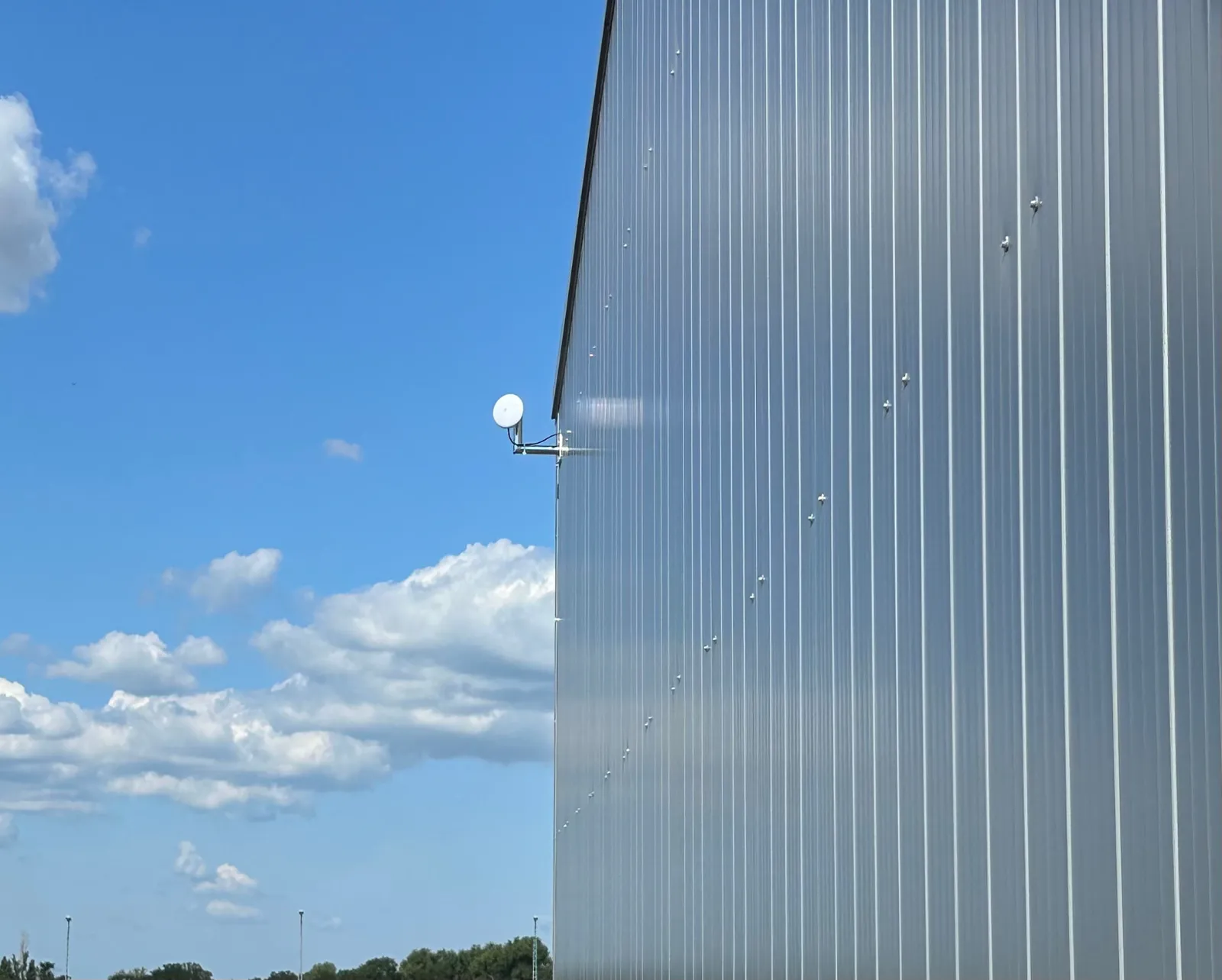 Ubiquiti Richtfunkantenne an Wandausleger einer Hallenfassade aus Trapezblech mit freier Sicht