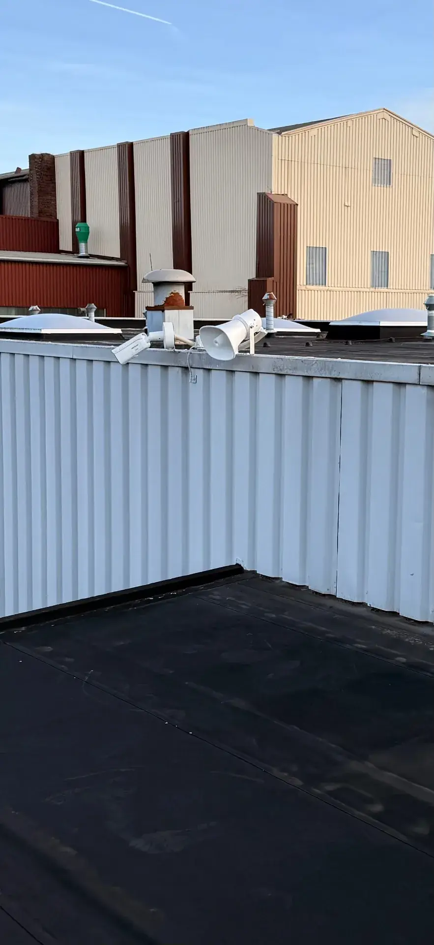 Bullet-Kamera und Lautsprecher auf einem Flachdach mit sauberer CAT7-Outdoor-Verkabelung