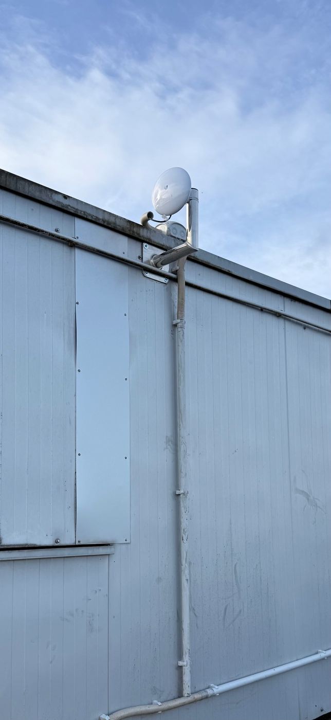 Ubiquiti NanoBeam Richtfunkantenne auf einem Flachdach montiert – Punkt-zu-Punkt-Verbindung zwischen zwei Gebäuden